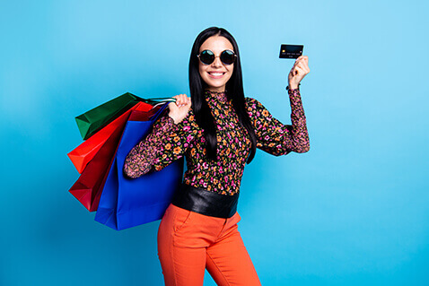 Smiling stylish woman in sunglasses with credit card